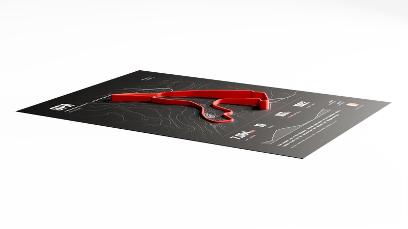 The red 3D-printed track on the art print seen from a low angle, so its changing height is visible along the lap.